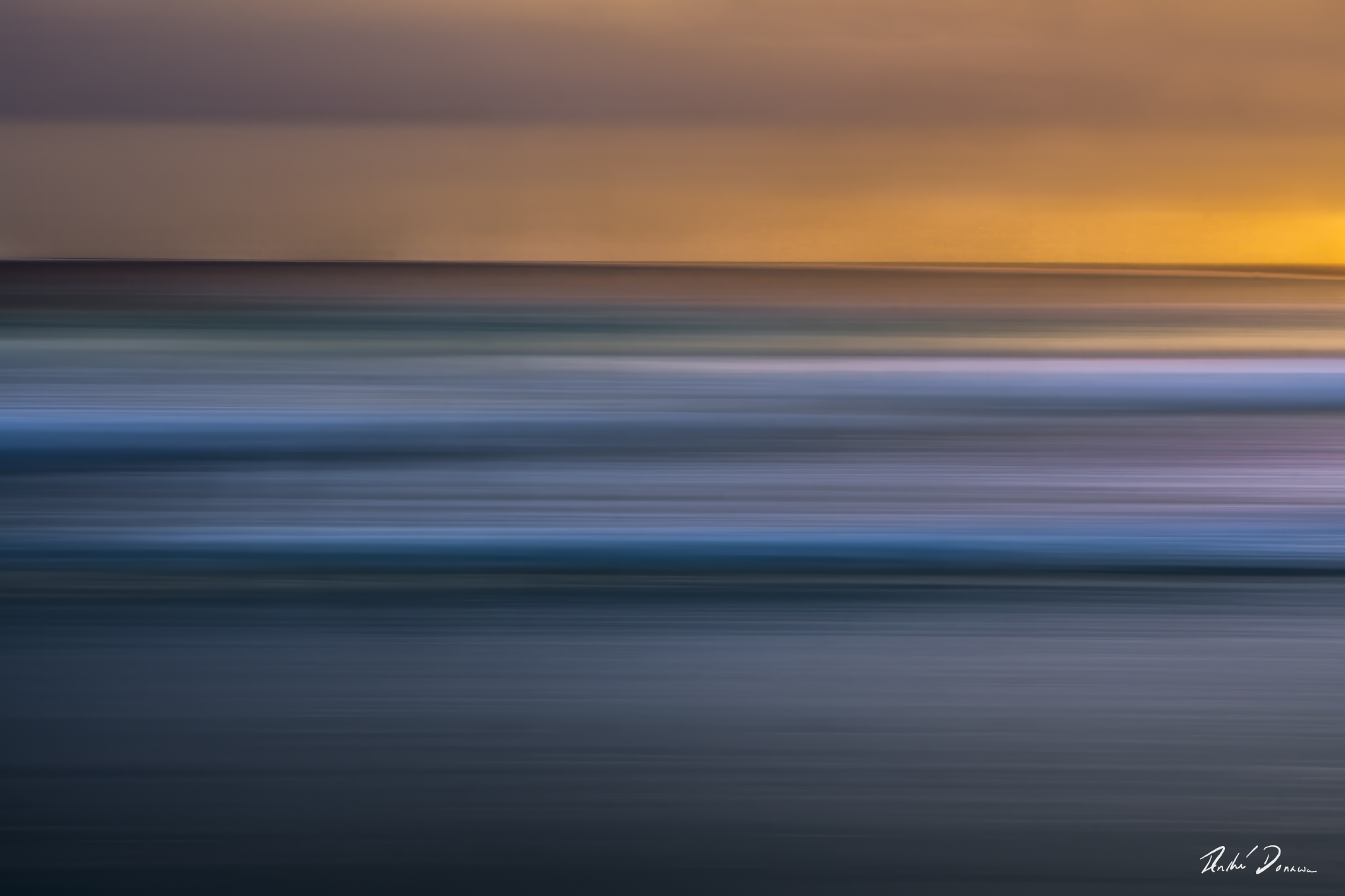 Abstract seascape created with Intentional Camera Movement photography during golden hour, featuring horizontal wave lines and a blurred ocean horizon