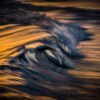 Abstract seascape created with Intentional Camera Movement photography during golden hour, featuring horizontal wave lines and a blurred ocean horizon